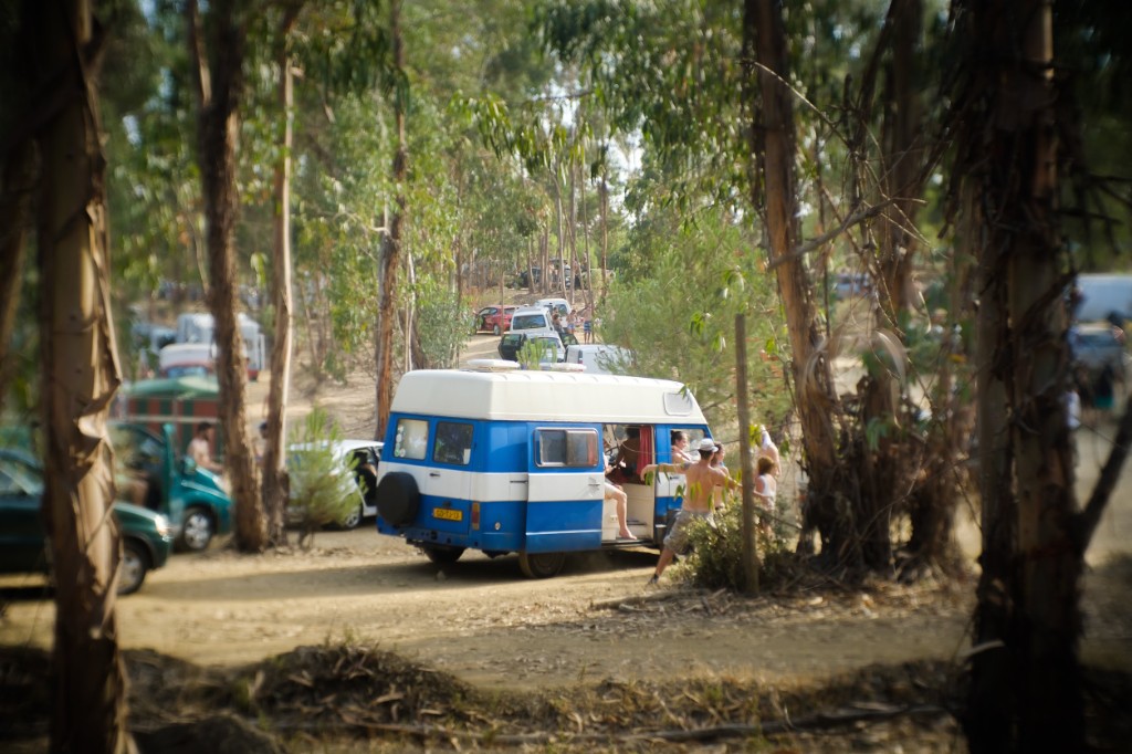 Festival-goers and camper vans on the dusty campsite ground