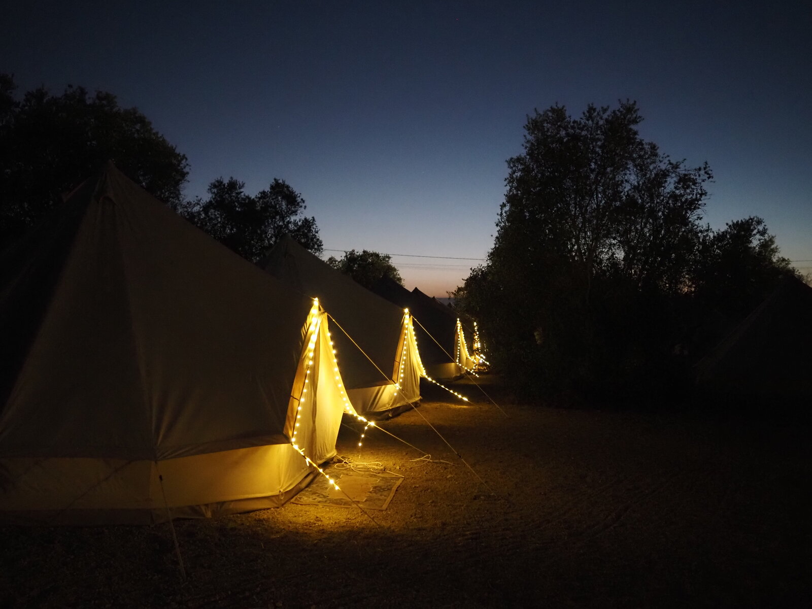 Glamping bell tents in the field beside the Rio Ceira